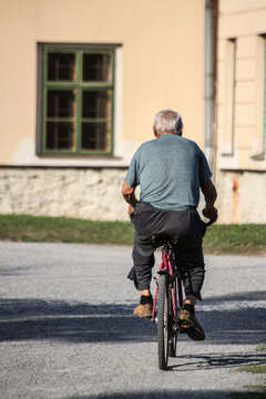 An Older Man From Behind Riding A Bicycle