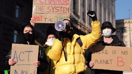 A group of people with banners and a megaphone in hand are protesting in the city square for save planet clean world act now  