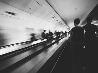 Long exposure of unrecognizable of commuters inside Parisian underground metro moving escalator...