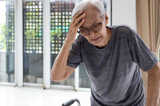Tired asian senior woman touch her head with hand,symptoms of vertigo illness or meniere’s disease affecting inner ear,feel unwell faint,giddiness,loss of balance while walking,old elderly with dizzy
