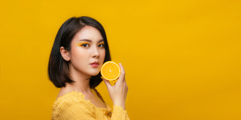 Isolated Asian girl smiling with holding orange fruit.