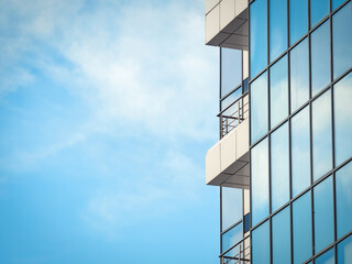 Modern glass office building agaist the cloudy sky.