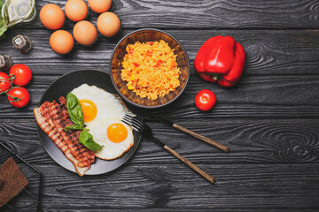 Plate with tasty eggs and bowl with rice on wooden background