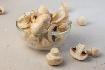 Whole and chopped mushrooms in a round transparent bowl