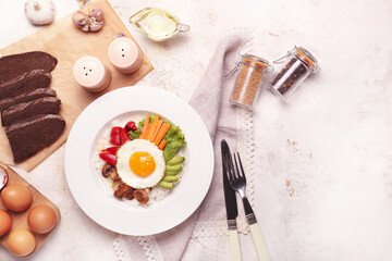 Plate with tasty egg, vegetables and rice on light background