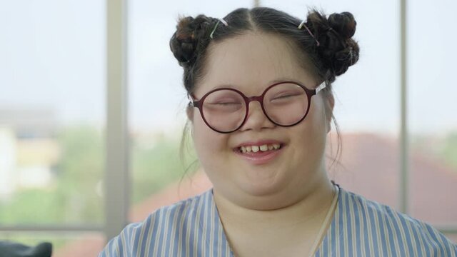 Portrait, girl with Down syndrome laughing

