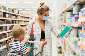 Mother and her little son in a supermarket during virus pandemic
