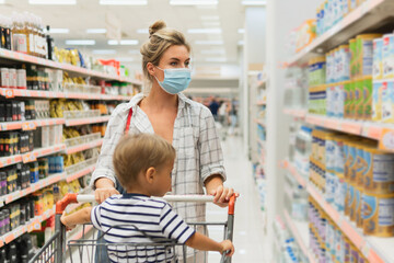 Mother and her little son in a supermarket during virus pandemic