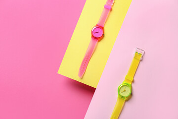 Stylish wrist watches on colorful background