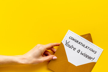 Female hand holds envelope with card You are a winner. Congratulations award letter