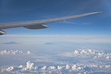 Wing of the plane on blue sky background. Aerial view of Blue sky and Cloud Top view from airplane window,Nature background. Sky and clouds. airplane wing