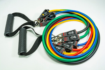 Sports accessory - expander with a carabiner .Colored rubber bands on a light background.