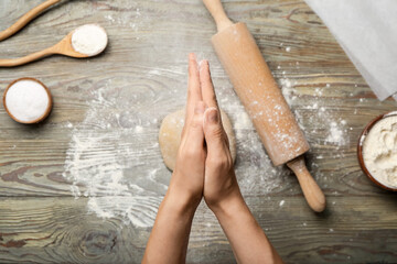 Woman making dough on wooden background