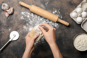 Woman making dough on grunge background