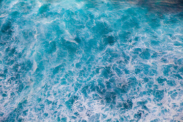 Blue sea texture with waves and foam.