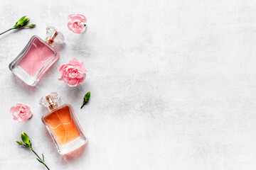 Flat lay of perfume bottles with flowers, top view