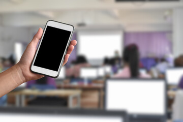 Blank touchscreen mobile phone in hand with blurred background, concept for using digital devices in various daily life around  the world.