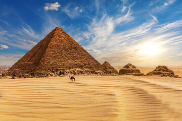 Fototapeta premium The Pyramid of Menkaure at sunset in Egypt and a camel nearby, Giza