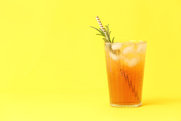 Glass of cold black tea with lemon on color background