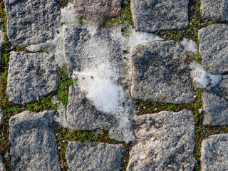 Slippery place of sidewalk with the rest of the trampled snow.