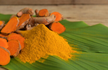 Turmeric powder and fresh turmeric (curcumin) on wooden background,copy space.