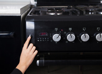 Obraz premium Gas stove and woman in the kitchen.