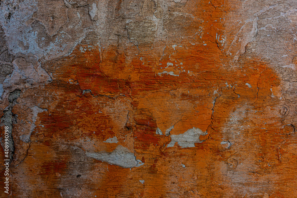 Wall mural wall surface with old plaster and traces of new orange paint.