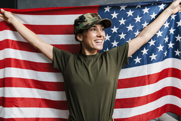 Happy soldier woman smiling while posing with american flag