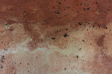 surface of the old cement plaster wall with damaged brown paint.
