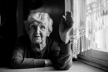 An old woman portrait in her house. Black and white photo.