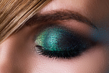 Female eye with a green eyeshadow - obrazy, fototapety, plakaty
