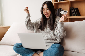 Happy young attractive woman shopping online