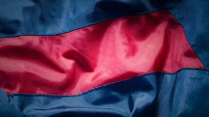 Detalle de chaqueta de chándal deportivo de táctel azul,  rojo y negro