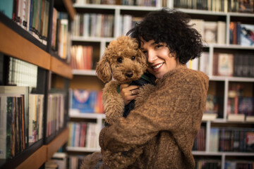 Woman with dog in library. 