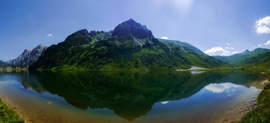 Fototapeta na wymiar gorgeous reflection in a mountain lake from the mountain landscape with sky panorama