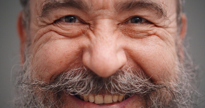 Close Up Portrait Of Carefree Mature Man Smiling Isolated On Gray Background