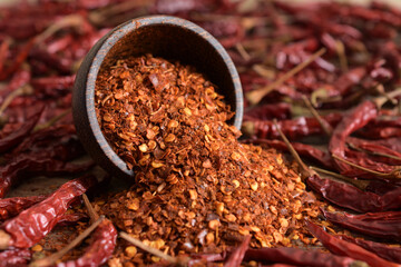 Cayenne pepper (Ground chili) and dried chili on a wooden background.
