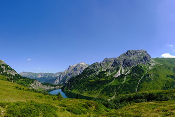 Fototapeta na wymiar gorgeous deep blue lake in a mountain landscape with blue sky panorama