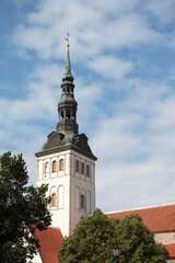 View of the famous Saint Nicholas church (Niguliste) with red roofs and castle in medieval walled old town of Tallinn Estonia in the Baltics region of Northern Europe