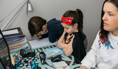 Woman teleworking with her son and angry daughter because she doesn't play with her. Selective...