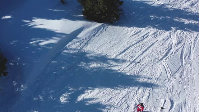 Snowbike riders in mountain valley in beautiful snow powder. Aerial video. Snowdirt bike with splashes and trail. Snowmobile winter sport riding
