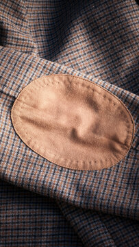 Codera de fieltro marr&oacute;n claro en una chaqueta de tweed azul y marr&oacute;n