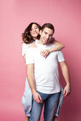 young cheerful caucasian couple together having fun on pink background, guy ang girl modern relationship, lifestyle people concept