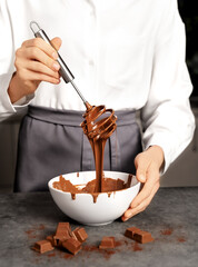 Young woman making chocolate truffle. Dark background. Delicious food concept. Great design for any purposes.