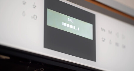 Close up of coffee machine control panel displaying coffee making process