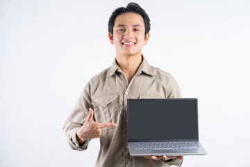 Portrait of male mechanic standing with laptop and pointing at it on white background