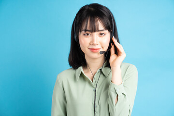 Beautiful asian female customer care worker is wearing headphones