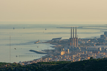 Obraz premium Panoramic view of the entire city of Barcelona and its surroundings. During sunset one day in late summer. We can see the Mediterranean sea completely flat.