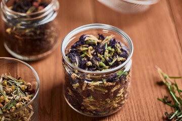 Close up on jars with blue butterfly pea flowers and herbs
