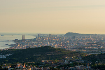 Fototapeta na wymiar Panoramic view of the entire city of Barcelona and its surroundings. During sunset one day in late summer. We can see the Mediterranean sea completely flat.